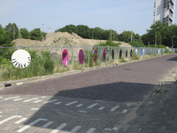 907666 Afbeelding van door schoolkinderen uit de buurt beschilderde cirkels op een hek langs het braakliggende terrein ...